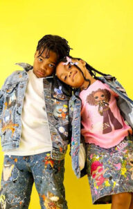 A brother and sister posing in front of a yellow background