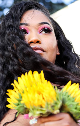 womans portrait headshot photo with a yellow flower in her hands